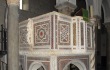 A large, freestanding pulpit carved from marble and decorated with sculptures and mosaics
